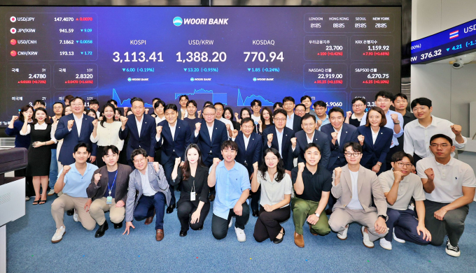 4일 우리은행 회현동 본점 자금시장그룹 딜링룸 전광판 점등식에 (둘째줄 왼쪽부터) 이정섭 브랜드홍보그룹장, 박형우 자금시장그룹장, 정진완 은행장, 양현근 상임감사위원, 한세룡 업무지원그룹장 등이 참석해 기념촬영을 하고 있다./사진=우리은행