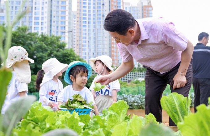 의정부시가 시민이 가꾸는 힐링 텃밭으로 틀텃밭 가꾸기 콘테스트 참가자를 모집한다고 5일 밝혔다. 김동근시장(오른쪽)이 텃밭가꾸기에 견학온 어린이와 상추를 수확하면서 이야기 하고 있다. /사진제공=의정부시
