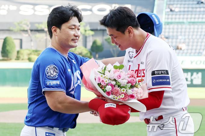 전격 은퇴를 선언한 삼성 오승환이 7일 오후 인천 미추홀구 SSG랜더스필드에서 열린 은퇴 기념행사에서 SSG 김광현으로부터 꽃다발을 선물 받고 있다. 2025.8.7/뉴스1 ⓒ News1 민경석 기자