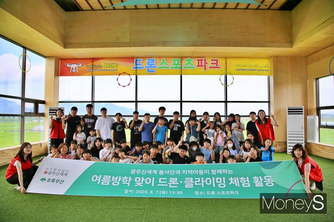 광주신세계 임직원 봉사단이 7일 드론 스포츠 파크에서 후원 아동 초청 이색체험 행사를 한 후 기념사진을 찍고 있다/사진=광주신세계 제공.
