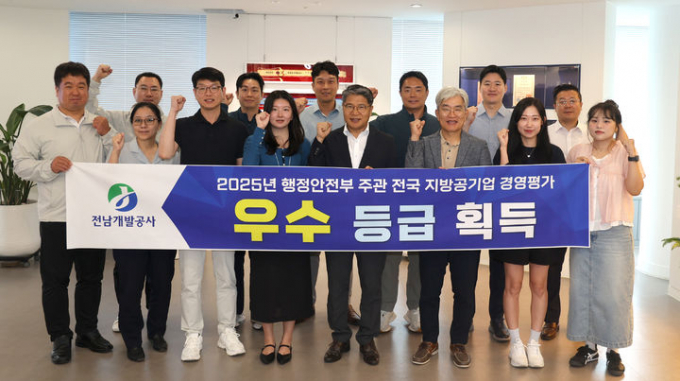 장충모 전남개발공사 사장(왼쪽 다섯번째)과 직원들이 행안부 주관 지방공기업 경영평가에서 2년 연속 우수기관에 선정된 것을 자축하고 있다./전남개발공사