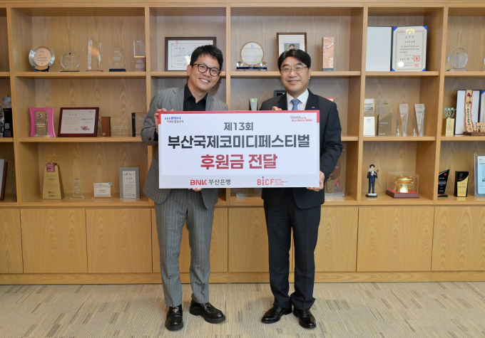 방성빈 BNK부산은행장(오른쪽)이 김준호 부산국제코미디페스티벌 집행위원장에게 후원금을 전달하고 기념촬영을 하고 있다./사진=부산은행