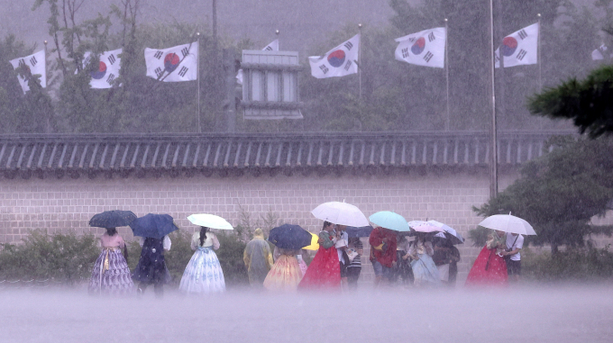 경의중앙선 등 일부 구간 전동열차 운행이 중단됐다. 사진은  13일 서울 종로구 국립고궁박물관 인근에서 외국인 관광객들이 우산을 쓴 채 이동하는 모습. /사진=뉴스1