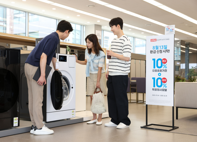 삼성전자 모델이 에너지 소비효율 1등급의 '세탁건조기'와 '에어컨' 제품의 설명을 듣고 있다. / 사진=삼성전자
