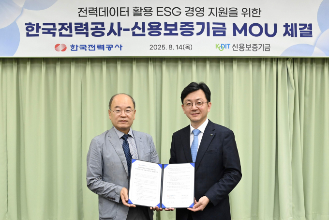 박종운 한전ICT기획처장(왼쪽)이 14일 김기완 신용보증기금 미래전략실장과 중소기업ESG 경영지원을 위한 협약을 맺은 후 기념촬영을 하고 있다./한전