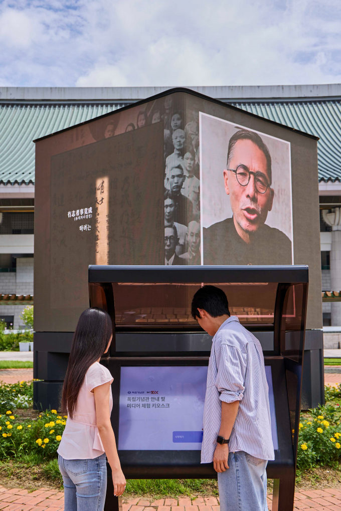 SK텔레콤이 독립기념관(관장 김형석)과 광복 80주년을 맞아 AI 기술로 복원한 독립운동가들의 생생한 모습과 목소리를 담은 특별 영상을 공개했다. 사진은  고화질로 복원한 독립운동가의 영상을 관람하고, 또렷하게 복원된 독립운동가의 육성을 들을 수 있는 LED 미디어큐브의 모습. /사진=SK텔레콤 제공
