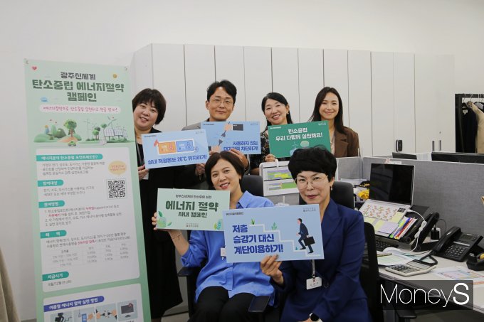 광주신세계 본관 사무실에서 직원들이 에너지 절약 실천을 위한 캠페인 안내물을 들고 있다/사진=광주신세계 제공.