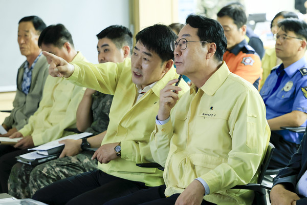 정명근 화성특례시장(앞줄 오른쪽)과 배정수 화성특례시의회 의장(앞줄 오른쪽 2번째)이 전시종합상황실의 상황보고와 관련해 의견을 나누고 있다. /사진제공=화성특례시