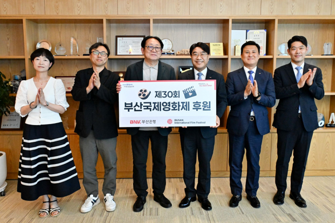 방성빈 BNK부산은행장(오른쪽 세 번째)이 18일 부산은행 본점에서 박광수 부산국제영화제 이사장(왼쪽 세 번째)에께 후원금을 전달하고 관계자들과 함께 기념촬영을 하고 있다./사진=부산은행