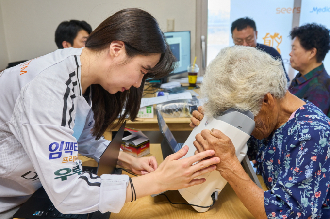 대웅제약이 의료 접근성이 떨어지는 지역에서 의료봉사를 진행했다. 사진은 AI(인공지능) 실명질환 진단 솔루션 위스키와 안저카메라 옵티나 제네시스를 활용해 안저 상태를 확인하는 대부도 주민. /사진=대웅제약