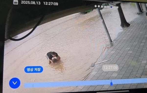 기록적인 폭우가 쏟아진 인천 지역에서 물난리를 막기 위해 맨홀 뚜껑을 직접 들어올린 30대 남성 김동희씨가 화제가 됐다. 사진은 김씨가 맨홀 뚜껑을 들어 올리는 모습. /사진=뉴스1