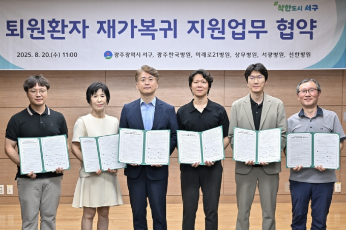김이강 광주시 서구청장(왼쪽 세번째)이 20일 서구청 이음홀에서 열린 퇴원환자 재가복귀 지원 업무협약식에서 협약서에 서명한 후 참석자들과 기념촬영을 하고 있다./사진=광주 서구청