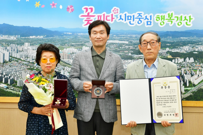 조현일 경산시장이 6·25전쟁에 참전해 공을 세운 故장해익 상병의 유가족에게 국방부장관을 대신해 화랑무공훈장을 전수하고 기념사진을 찍고 있다. /사진=경산시