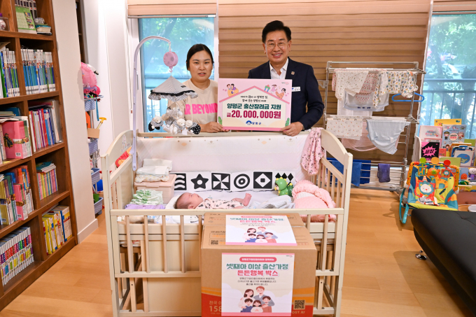 전진선 양평군수(오른쪽)가 지난 25일 다섯째 아이를 출산한 다자녀 가정에 방문해 출산 축하 물품을 전달하고 사진 촬영을 하고 있다. /사진제공=양평군