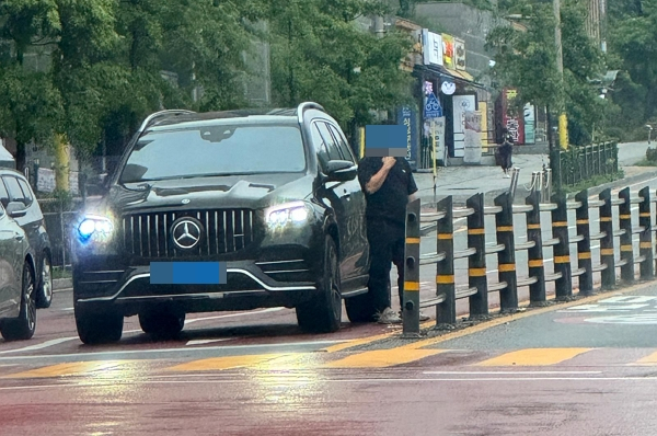 차에서 내려 담배를 피우는 남성 운전자 모습이 포착됐다. 사진은 차에서 내려 흡연하는 남성 운전자의 모습. /사진=보배드림 캡처