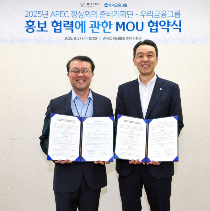 김지준(왼쪽) APEC 정상회의 준비기획단 기획실장과 이정섭(오른쪽) 우리금융지주 브랜드부문장이 지난 27일 APEC 정상회의 홍보협력 업무협약식에서 기념사진을 촬영하는 모습./사진=우리금융그룹