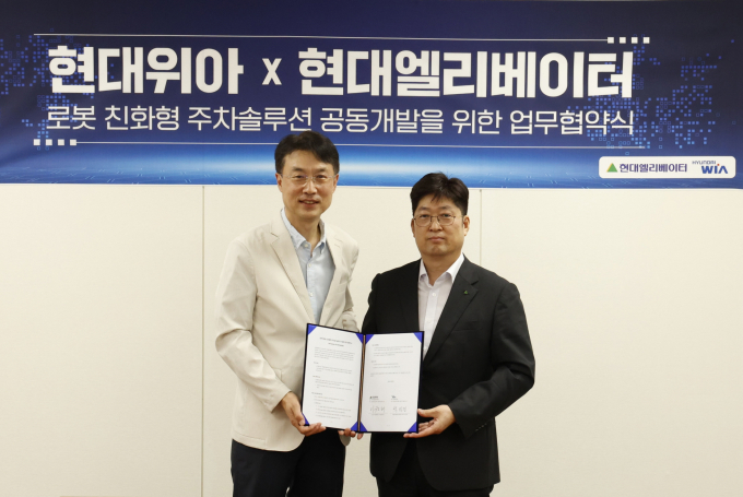 백익진(왼쪽) 현대위아 모빌리티솔루션사업부 상무와 이원해 현대엘리베이터 승강기사업본부장(상무)가 지난 28일 경기도 의왕연구소에서 '로봇 친화형 주차솔루션 공동개발을 위한 업무협약식'을 진행했다. /사진=현대위아