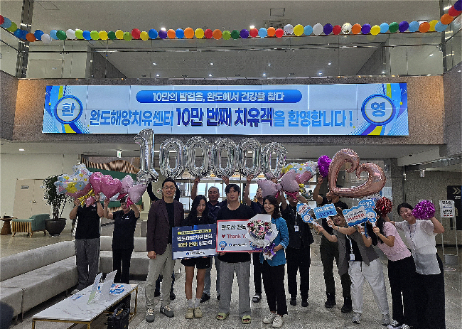 완도군 관게자들이 완도해양치유센터 누적 치유객 10만 명 달성 이벤트 행사를 하고 있다./완도군