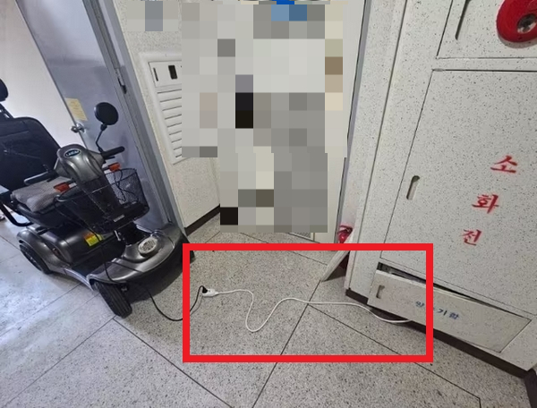 아파트 입주민이 전동 휠체어로 방화문을 가로막고 공용 전기로 충전하는 모습이 포착됐다. 사진은 한 아파트 입주민이 공용 전기를 끌어다 전동 휠체어를 충전하는 모습. /사진=보배드림 인스타그램 캡처