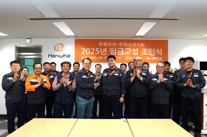 김희철 한화오션 대표이사(앞줄 왼쪽에서 네번째)와 김유철 전국금속노조 경남지부 한화오션지회 지회장(앞줄 왼쪽에서 다섯번째) 등 노사 교섭위원들이 임금 교섭 조인식을 마친 후 기념촬영을 하고 있다. /사진=한화오션