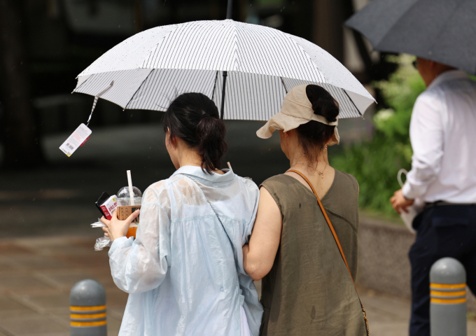 4일 전국에 무더운 날씨가 이어지고 중부지방 중심으로 비가 내릴 예정이다. 사진은 지난달 25일 서울 종로구 일대를 지나는 시민들이 우산을 쓰고 걷는 모습. /사진=뉴스1