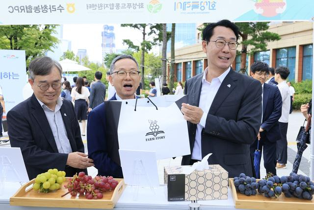  4일 정명근 화성시장(오른쪽 첫번째)이 국회 로컬푸드 직거래 장터에서 송산포도를 살펴보며 농업 관계자들과 대화를 하고 있다. /사진제공=화성특례시