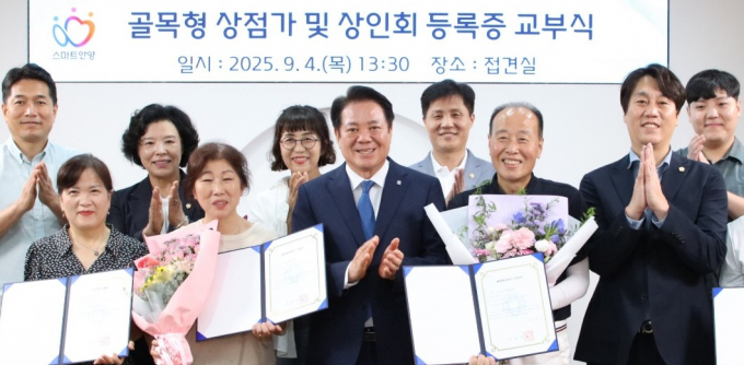 4일 시청에서 열린 석수본동, 인덕원동 골목형상점가 지정 교부식에서 최대회 시장(앞줄 가운데)과 상점가 상인회장 등이 기념촬영하고 있다.  /사진제공=안양시  