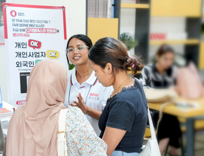 부산은행 외국인 서포터즈(가운데)가 고객에게 서비스를 제공하고 있다./사진=부산은행