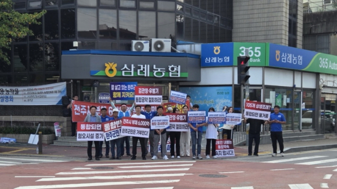 완주군의회 유의식 의장과 완주-전주 통합 반대대책위원회, 완주군 라온청년새마을 연대 회원등 30명이 삼례농협 앞에서 완주-전주 행정통합 반대 캠페인을 하고 있다./사진=완주군