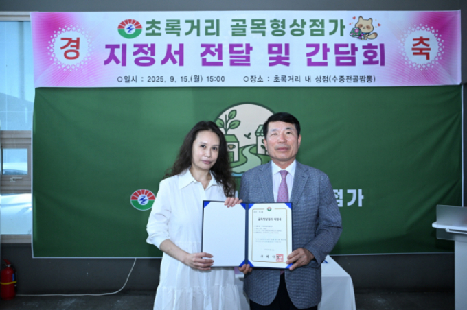 백경현 구리시장(오른쪽)이 지난 15일 ‘초록 거리 골목형 상점가’ 지정서를 갈매 순환로 204번 길 일대 상인회에 전달하고 있다. /사진제공=구리시 