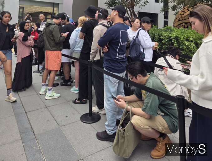 19일 오전 서울 중구 '애플 명동' 앞 거리에서 오랜 기다림에 지친 구매자들이 바닥에 앉아 휴식을 취하고 있다. /사진=김미현 기자