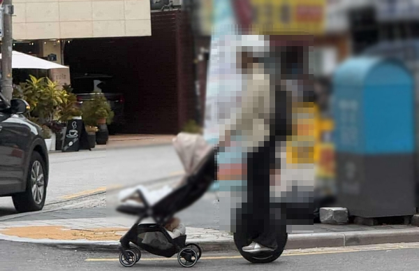 서울 강북구 한 도로에서 외발 전동휠을 탄 채로 유아차를 미는 남성이 포착됐다. 사진은 서울 강북구 한 도로에서 목격된 외발 전동휠을 탄 남성이 유모차를 미는 모습. /사진=온라인커뮤니티 캡처