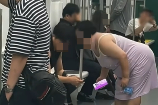 서울 지하철 2호선에서 '풍선껌 빌런'이 포착됐다. 사진은 승객에 얼굴을 들이밀고 풍선껌을 터뜨리는 여성의 모습. /사진=보배드림 캡처