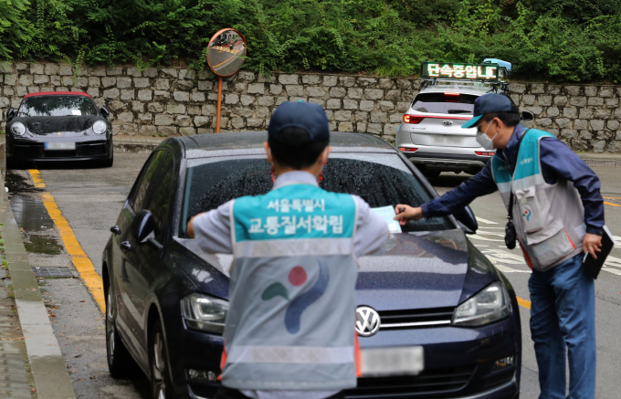 국정자원 화재 여파로 서울시 각 자치구가 불법 주·정차 관련 단속 내용을 손으로 기록하고 있다. 사진은 서울시내 한 초등학교 인근에서 관계자들이 어린이 보호구역 불법 주정차 단속을 하던 모습. 사진은 기사 내용과 관련 없음. /사진=뉴시스