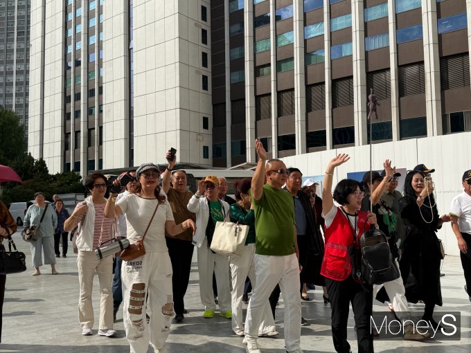 관광버스에서 내린 중국 단체 관광객들이 손을 흔들며 가이드를 따라 롯데면세점으로 향하고 있다. /사진=김유나기자