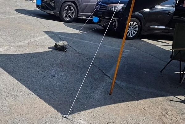 공영주차장 바닥에 드릴로 구멍을 뚫어 텐트를 고정한 '무개념 캠핑족'이 포착됐다. 사진은 경남 거제 흥남해수욕장 공영주차장에서 포착돼 캠핑족 모습. /사진=온라인커뮤니티 캡처