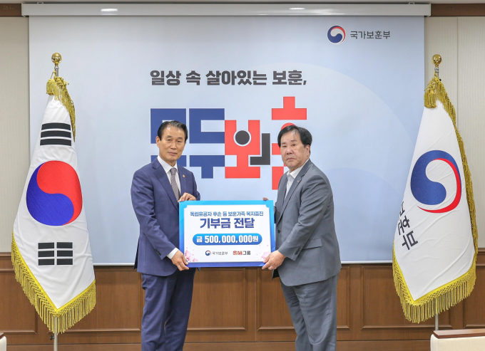 우오현 SM그룹 회장(오른쪽)이 13일 오전 정부세종청사에서 열린 국가보훈부의 전 국민 보훈 기부 프로젝트 ‘모두의 보훈 드림’ 후원금 전달식에서 권오을 장관과 기념촬영을 하고 있다. /사진=SM그룹