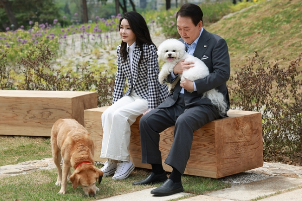 윤석열 전 대통령 부부가 반려견을 위한 의전을 요구했다는 주장이 전해졌다. 사진은 윤석열 전 대통령과 부인 김건희 여사가 2023년 5월4일 서울 용산 대통령실 앞 미군기지 반환부지에 조성된 용산어린이정원 내 전망언덕에서 기념식수를 마친 뒤 반려견 써니, 새롬이와 휴식을 취하고 있는 모습. /사진=뉴시스(대통령실 제공)