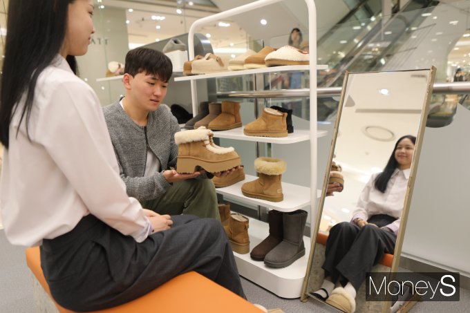 롯데백화점 광주점 3층 어그 매장 직원이 여성 고객에게 양털 슈즈를 추천하고 있다/사진=롯데백화점 홍보 3팀 제공.