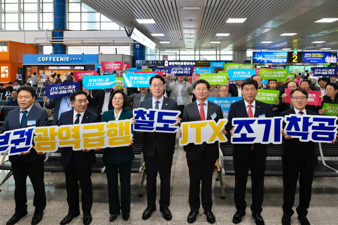 14일 청주공항에서 열린 '중부권 광역급행철도(JTX) 조기착공 촉구 결의대회'에 참석한 7개 도시 관계자들이 팻말을 들고 있다. /사진제공=용인특례시