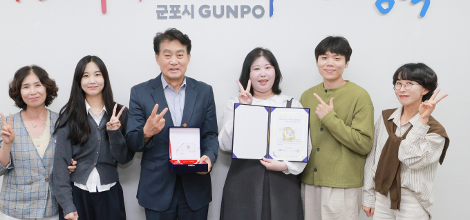 대한민국 SNS 대상' 최우수상 수상한 군포시 관계자들이 하은호 군포시장(왼쪽에서 세 번째)에게 상장을 전하는 모습.  /사진제공=군포시