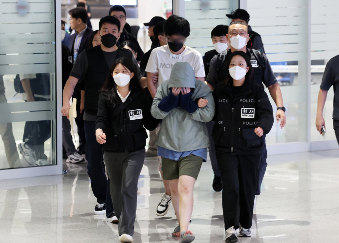  캄보디아 당국의 범죄단지 단속으로 적발돼 구금됐던 한국인들이 18일 오전 인천국제공항 2터미널을 통해 송환되고 있다.  이번 송환 대상자들은 이른바 '웬치'로 불리는 캄보디아 범죄단지에서 보이스피싱이나 로맨스 스캠(사기) 등 범죄에 가담한 혐의를 받고 있다. 이들은 호송 차량 23대 등을 타고 충남경찰청 등 6개 관할 경찰관서로 압송된다./사진-뉴스1