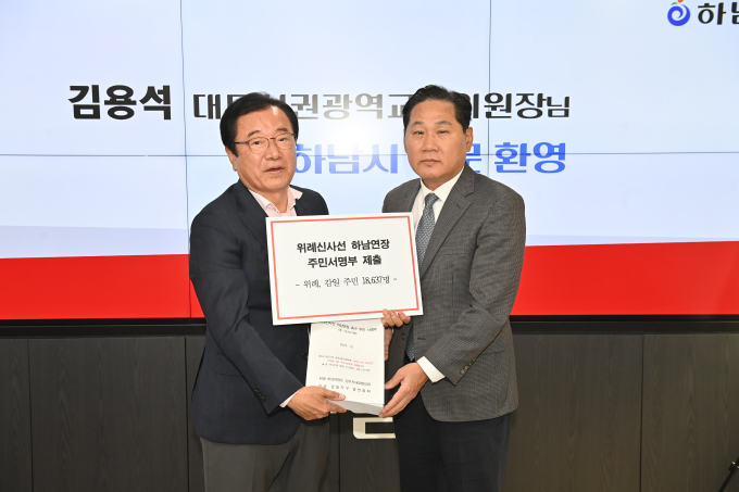 이현재 하남시장(왼쪽)이 지난 24일 하남시청을 방문한 김용석 대도시권광역교통위원회 위원장과 만나 위례신사선 하남연장 등 시의 핵심 광역교통 현안 논의와 적극적인 지원을 요청하며 주민서명부를 전달하고 있다. /사진제공=하남시