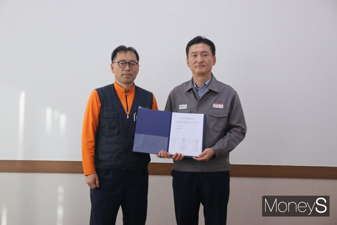 금호타이어 2025 단체교섭 조인식에서 정일택 대표이사(오른쪽)와 황용필 노조 대표지회장이 서명한 합의서를 교환하고 기념촬영을 하고 있다/사진=금호타이어 제공.