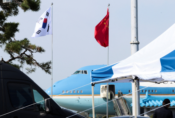 도널드 트럼프 미국 대통령과 시진핑 중국 국가주석이 30일 한국 김해국제공항에서 만났다. 사진은 30일 부산 김해국제공항에서 펄럭이는 태극기와 중국 오성홍기 뒤로 트럼프 대통령 전용기인 '에어포스원'의 모습. /사진=로이터