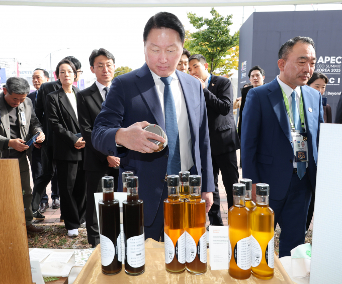 최태원 대한상의 회장이 APEC CEO 서밋 현장에 ‘K-사회적가치 기업관’에 방문에 제품을 둘러보고 있다. / 사진=대한상의