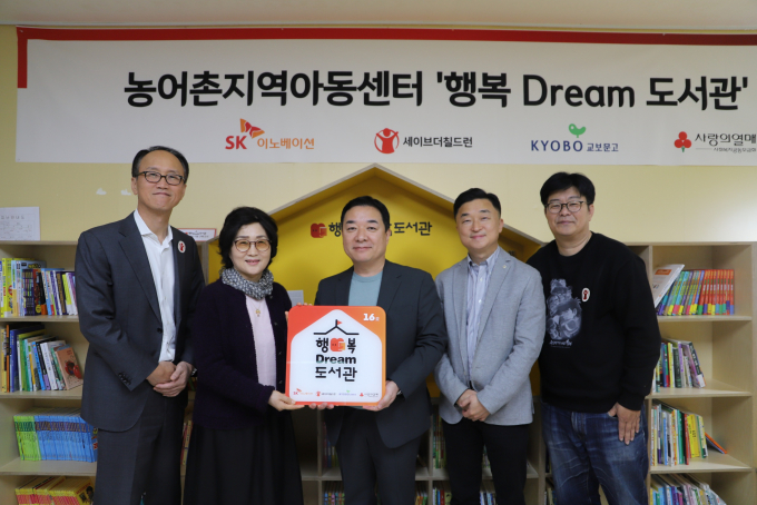 SK이노베이션이 전국 농어촌 지역아동센터 10곳에 아이들을 위한 작은 도서관을 열고 어린이용 도서 8000여권을 기증한다.  사진은 지난 1일 경기 포천시 일동밀알지역아동센터에서 '행복Dream 도서관' 개소식을 열고 관계자들이 기념 사진을 촬영하고 있는 모습. /사진=SK이노베이션 제공