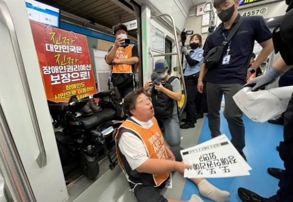전국장애인차별철폐연대 시위로 지하철 1호선 서울역에서 열차가 양방향 무정차 통과하고 있다. 사진은 전국장애인차별철폐연대 '65차 출근길 지하철 탑니다' 포스터 속 시위 모습. /사진=전국장애인차별철폐연대 홈페이지 캡처