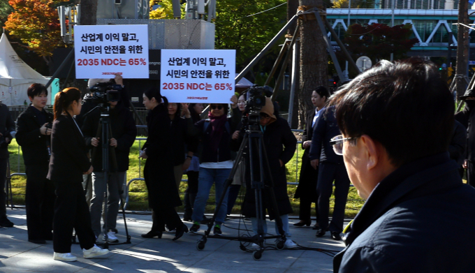 산업계가 현실적인 감축 여력과 산업 경쟁력을 함께 고려한 합리적인 수준의 2035년 국가온실가스감축목표(NDC) 및 배출권거래제 제4차 계획기간 할당계획 수립을 정부에 요청했다.  사진은 지난 10월 위기비상행동 회원들이 2035년 국가 온실가스 감축목표(NDC) 65% 수립을 촉구하는 피켓을 들어보이고 있는 모습. /사진=뉴시스
