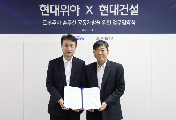 백익진 현대위아 상무(왼쪽)와 김재영 현대건설 기술연구원장이 7일 경기도 의왕시 현대위아 의왕연구소에서 열린 ‘로봇 친화형 주차솔루션 공동개발을 위한 업무협약식’에서 기념 사진을 찍고 있다. /사진=현대위아